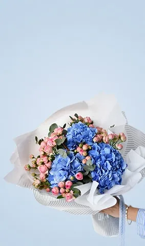 Birthday bouquet with blue hydrangeas and pink roses on light blue background