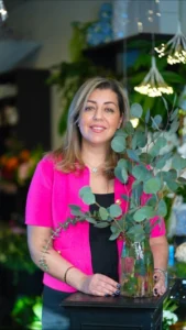 Tooka Florist owner holding a fresh eucalyptus arrangement in her flower shop