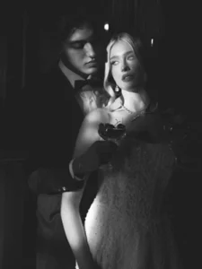 Romantic black and white portrait of a bride and groom holding champagne glasses with cherries