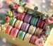 Colorful French macaron gift box with pink roses and eucalyptus in sunny lighting